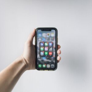 LinkedIn List growth Business man holding phone with LinkedIn app on screen